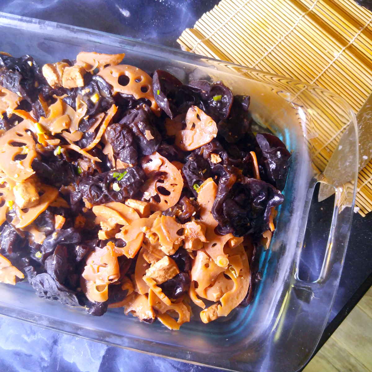 Lotus root wood ear mushroom tofu stir fry in a serving dish