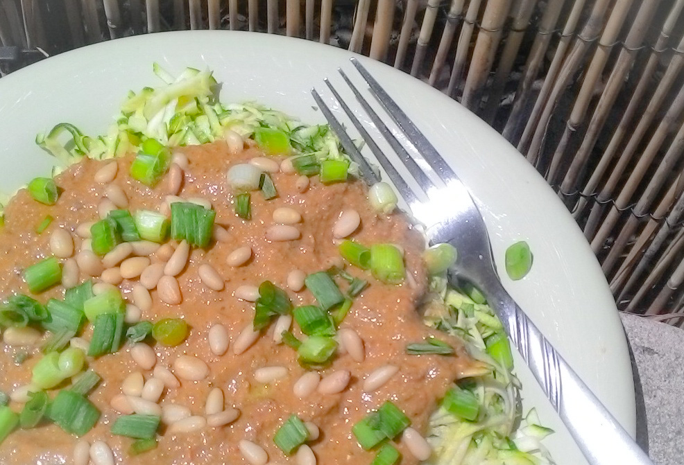 Raw vegan zucchini pasta with creamy tomato, basil, and pine nut sauce